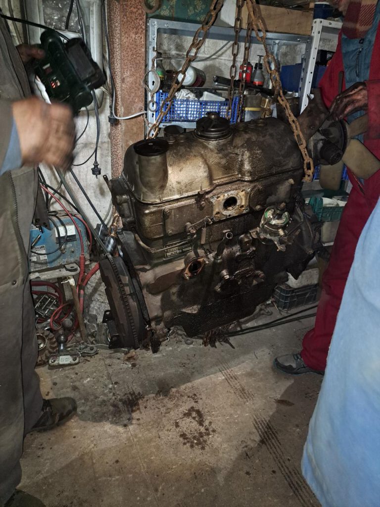 L’ancien moteur suspendu à un palan